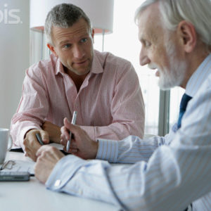 Two Business Men Sitting at Desk in Office